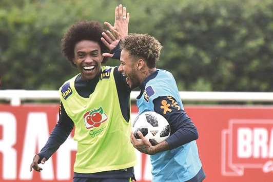 Brazilu2019s Neymar (right) celebrates with teammate Willian during a training session in London yesterday. (AFP)