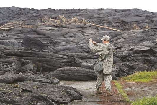 Tech Sgt Andrew Lee Jackson, of the Hawaii National Guard, takes photos of the Kilauea lava flow, in Leilani Estates near Pahoa.