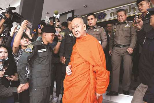 Monk Phra Phrom Prasitthi, centre, the abbot of Wat Saket Buddhist temple, is escorted by Royal Thai police from the Crime Suppression Division after surrendering himself on allegations of corruption in Bangkok yesterday.