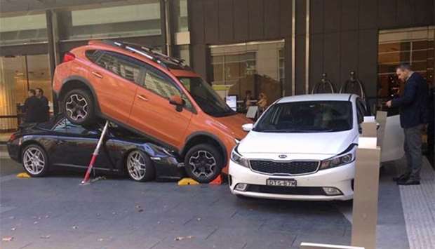 Hotel staff and guests can be seen near a car accident outside the main entrance of a hotel in the central business district of Sydney on Thursday.