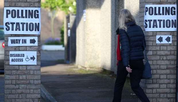 A woman enters a polling station as voting begins in local government elections in London