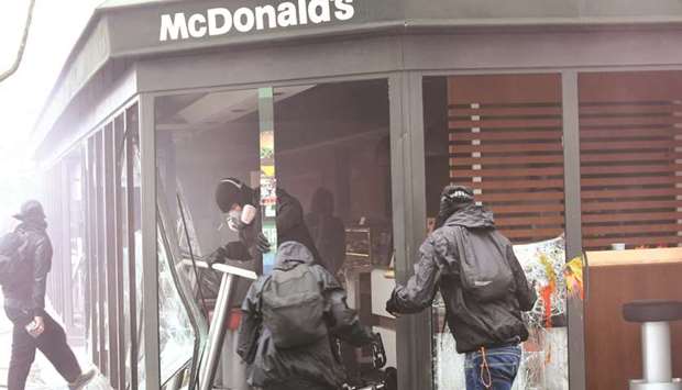 Masked protesters ransack a McDonaldu2019s outlet in Paris on Tuesday.