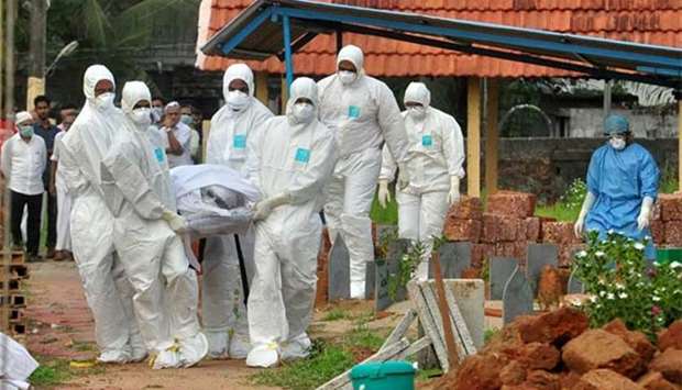 Doctors and relatives wearing protective gear carry the body of a victim, who lost his battle against the brain-damaging Nipah virus, during his funeral in Kozhikode, Kerala, last week.
