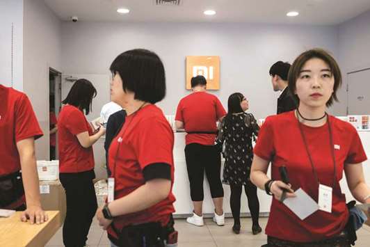 Xiaomi employees work in a shop in Beijing. Chinese smartphone maker Xiaomi has kicked off what is expected to be the worldu2019s biggest initial public offering of shares in years after it filed documents with Hong Kongu2019s stock exchange.