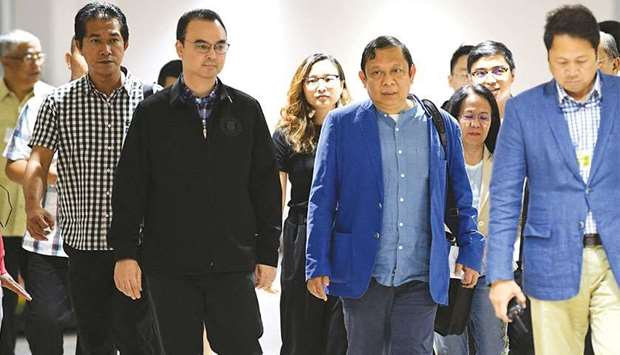Foreign Affairs Secretary Alan Cayetano (front left) walks with former Philippine ambassador to Kuwait, Renato Pedro Villa, shortly after Villa arrived at the airport in Manila.
