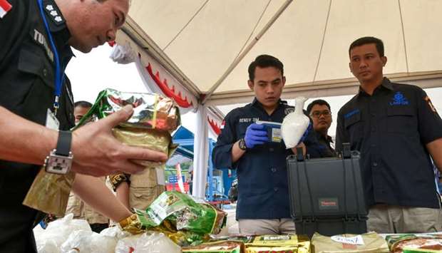 Indonesian police and drugs agency members display packs of methamphetamine in Jakarta on before authorities destroyed 2.6 tons of crystal methamphetamine.