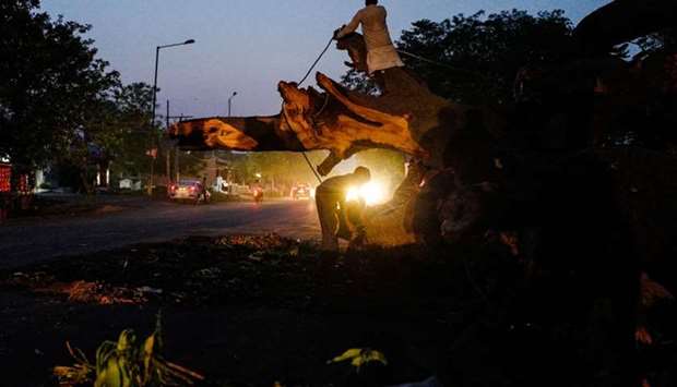 An Indian man chops a tree which fell onto a road during a storm in Agra yesterday.