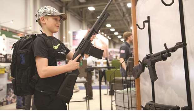 Blaise Maliskey, age 11, tries out a firearm in an exhibit hall at the NRAu2019s annual convention in Dallas.