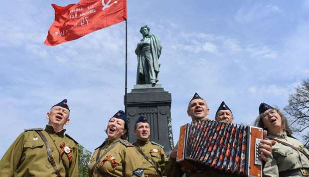 People dressed in Soviet army uniforms sing in front of a monument of poet Alexander Pushkin an hour before the start of an unauthorized anti-Putin rally called by opposition leader Alexei Navalny. AFP