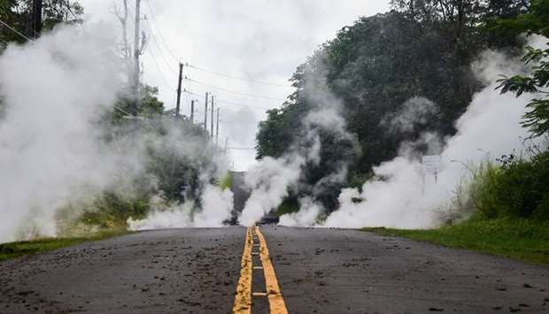 Steam rises from a fissure on a road in Leilani Estates subdivision on Hawaii's Big Island yesterday. Up to 10,000 people have been asked to leave their homes on Hawaii's Big Island following the eruption of the Kilauea volcano that came after a series of recent earthquakes