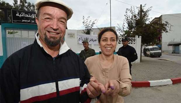 A man and a woman show their ink-stained fingers after voting in Ben Arous, near the Tunisian capital Tunis, on Sunday.