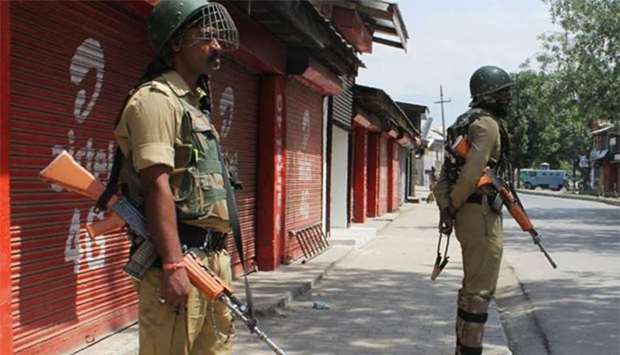 Central Reserve Police Force personnel stand guard during imposed restrictions in Srinagar on Friday.