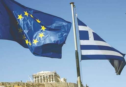 A European Union flag (left) flies alongside a Greek national flag beneath the Parthenon temple on Acropolis Hill in Athens (file). On the eighth anniversary of the euro-areau2019s biggest bailout, Greece is closer than ever to breaking free from its creditorsu2019 oversight and trying its luck raising money on its own.