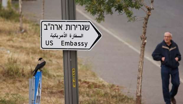 A man walks next to a road sign directing to the US embassy, in the area of the US consulate in Jerusalem.