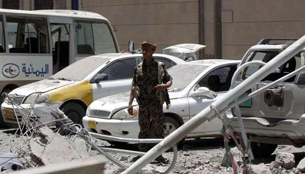 Yemenis check the site of air strikes at the president office in the capital Sanaa