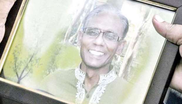 A man holds a portrait of Bangladeshi professor Rezaul Karim Siddique