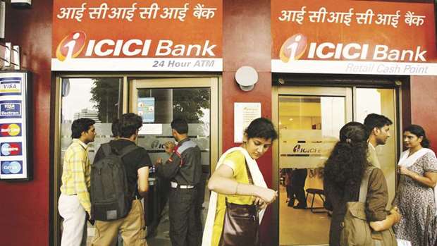 Customers wait for their turn to withdraw cash from an ICICI Bank ATM in New Delhi.  Current and former top bankers from at least four lenders, including ICICI Bank,  are under investigation for alleged impropriety over their lending decisions.