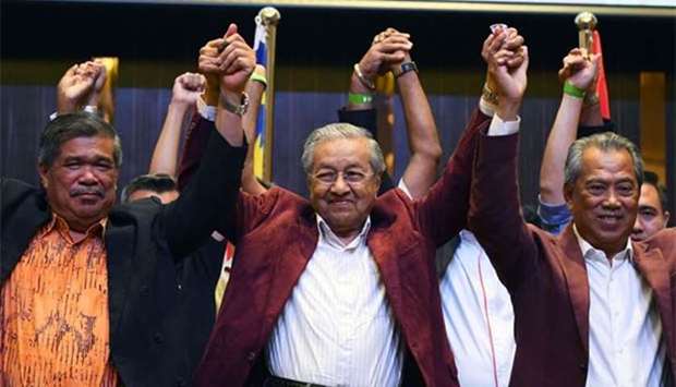 Mahathir Mohamad celebrates with his coalition leaders during a press conference in Kuala Lumpur early Thursday.