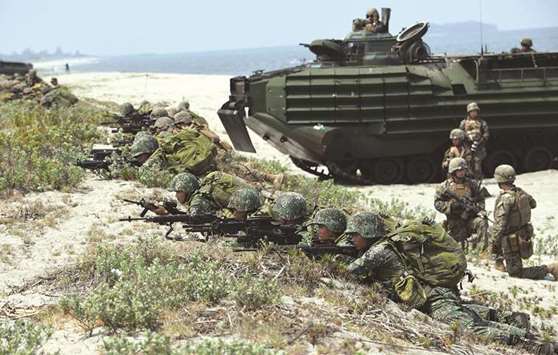 Philippine and US marines take position next to assault amphibious vehicles (AAV) as they simulate an amphibious landing as part of the annual joint military exercise at the beach of Philippine navyu2019s training camp in San Antonio, Zambales province.