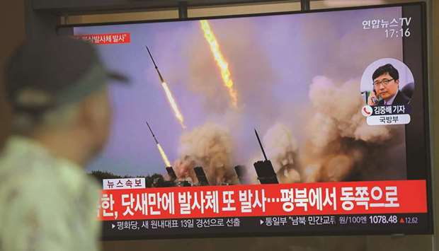 People watch a television news programme showing file footage of North Koreau2019s projectile weapons, at a railway station in Seoul yesterday.