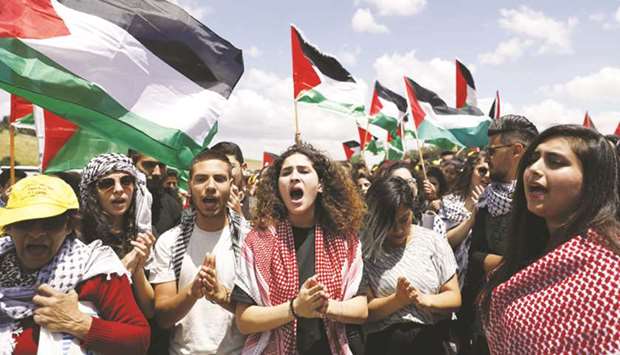 Palestinian and Israeliu2019s Arab minority protesters wave Palestinian flags as they march for the right of return for refugees near Umm al-Fahm in northern Israel yesterday.
