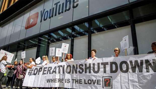 Anti-knife crime activists, with their hands painted red to represent blood, demonstrate outside the UK offices of YouTube in London