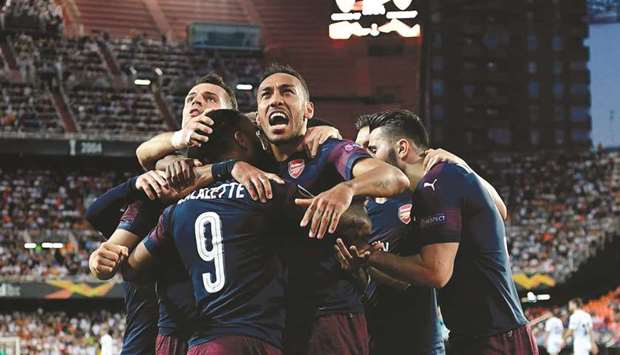 Arsenalu2019s Gabonese striker Pierre-Emerick Aubameyang (C) celebrates with teammates after scoring  against Valencia at the Mestalla stadium in Valencia on Thursday.