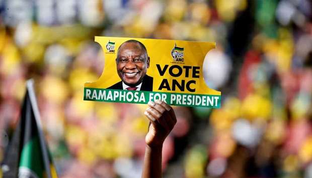 A supporter holds a placard with the face of President of South Africa's governing African National Congress Cyril Ramaphosa