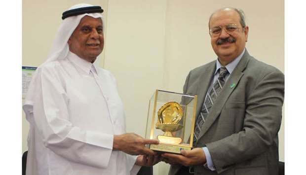 HE Abdullah bin Hamad al-Attiyah being honoured by Dr Riadh Fadhil.
