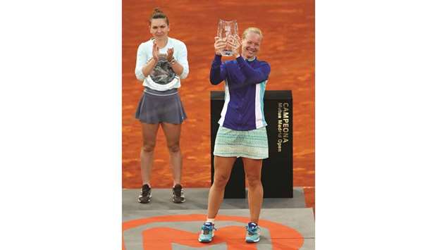 Netherlandsu2019 Kiki Bertens celebrates with the trophy after winning the Madrid Open final against Romaniau2019s Simona Halep (left) yesterday. (Reuters)
