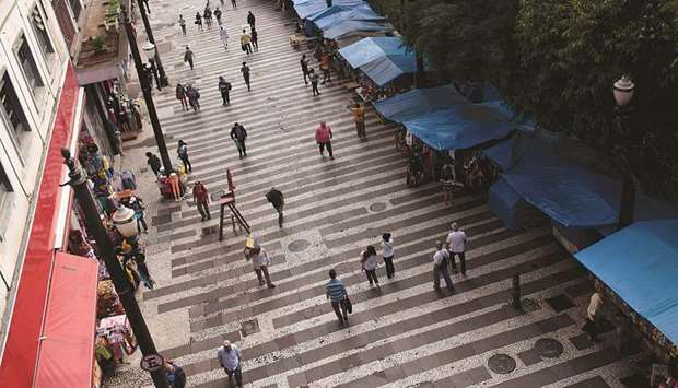 Pedestrians and shoppers walk through a shopping district in downtown Sao Paulo (file). Leading indicators suggest Brazilu2019s economy may have contracted in the first quarter, and the recovery is being hampered by political uncertainties that are delaying investment decisions.