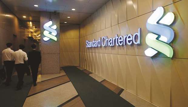 People walk inside the main branch of Standard Chartered in Hong Kong. StanChart is buying back ordinary shares for the first time in more than 20 years as chief executive officer Bill Winters seeks to put misconduct and profitability woes behind the Asia-focused lender.