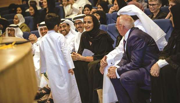 HE Sheikha Hind bint Hamad al-Thani interacting with a child at the ceremony yesterday as other dignitaries look on.