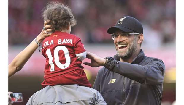 Liverpoolu2019s German manager Jurgen Klopp (right) greets a child at the end of the English Premier League match against Wolverhampton Wanderers at Anfield. (AFP)
