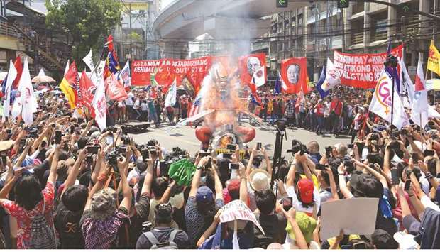 Workers burn an effigy representing President Rodrigo Duterte during a demonstration marking Labour Day in Manila, yesterday.