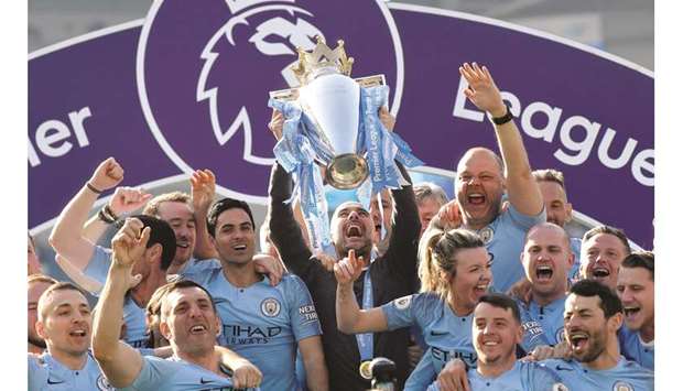 Manchester City manager Pep Guardiola lifts the trophy as they celebrate winning the Premier League on the final day of the competition yesterday.