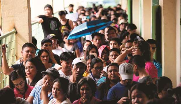 People wait for their turn to vote at a voting precinct in Culiat Elementary School in Manila, yesterday.