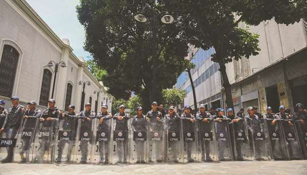Members of Venezuelau2019s Bolivarian National Police stand guard near the Federal Legislative Palace, which houses both the opposition-led National Assembly and the pro-government National Constituent Assembly, in Caracas yesterday.
