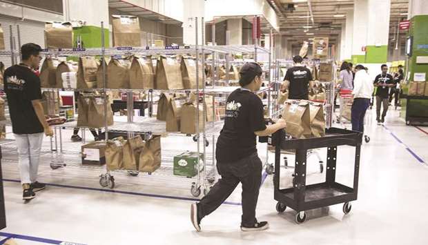 Employees prepare orders for shipping at an Amazon Prime Now fulfilment centre in Singapore. Amazon has started adding technology to a handful of warehouses in recent years, which scans goods coming down a conveyor belt and envelopes them seconds later in boxes custom-built for each item.