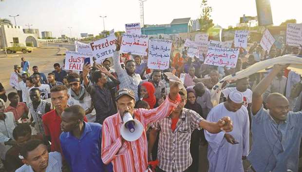 Sudanese protesters chant slogans and wave placards during a demonstration in Khartoum, yesterday.