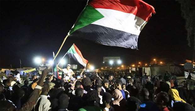 Sudanese protestors celebrate after an agreement was reached with the military council to form a new transitional government of three years, in Khartoum