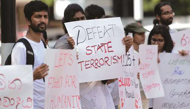 Sri Lankans hold placards as they demonstrate against the anti-Muslim mob attacks in Colombo.