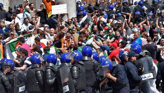Algerian protesters scuffle with riot police during an anti-government demonstration outside La Grande Poste (main post office) in the capital Algiers