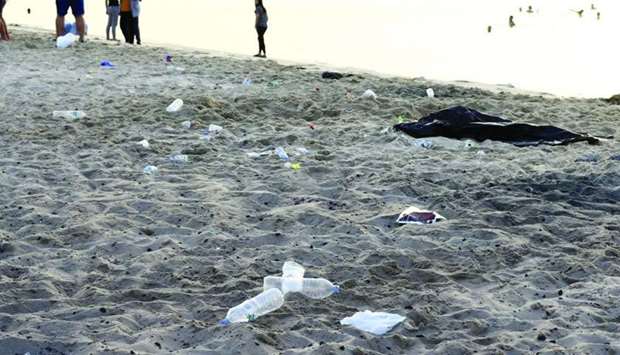 Small pieces of charcoal and plastic bottles leave Mesaieed Beach darker and dirtier. PICTURES: Jayan Orma