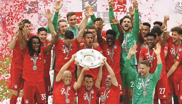 Bayern Munich players Arjen Robben (front left), Rafinha (centre) and Franck Ribery celebrate with the trophy after winning the Bundesliga title in Munich. (Reuters)