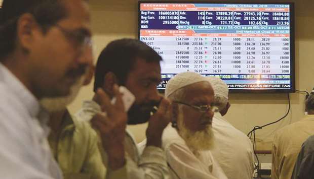 Pakistani stockbrokers watch the latest share prices on their monitors during a trading session at the Pakistan Stock Exchange in Karachi. The PSX benchmark KSE-100 index lost over 900 points in intra-day trading during Fridayu2019s session.