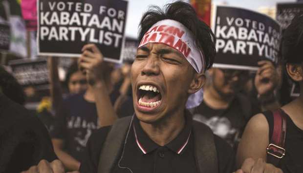 Protesters shout slogans accusing the government of rigging the mid-term elections near the Philippine International Convention Centre in Manila, where the Commission on Elections (Comelec) was tallying votes in the mid-term polls.