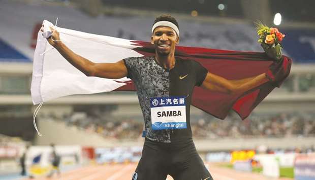 Qataru2019s Abderrahman Samba with the Qatari national flag celebrates winning the 400m hurdles at the Shanghai Diamond League meet yesterday.