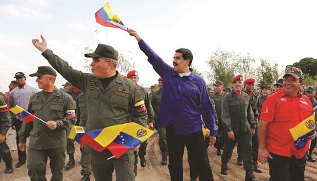 Venezuelau2019s President Nicolas Maduro and Defence Minister Vladimir Padrino (left) wave national flags during the march of loyalty with the Superior Staff of the Venezuelau2019s Bolivarian National Armed Forces in the Zodi Aragua state on Friday.