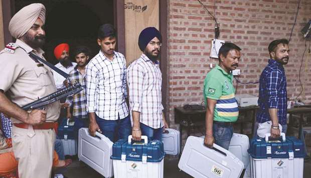 Eelection officials carry Electronic Voting Machines (EVM) and Voter-Verified Paper Audit Trail (VVPAT) from a distribution centre in Amritsar, Punjab, yesterday on the eve of the seventh and final phase of general elections.